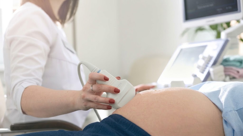 Doctor performing an early pregnancy scan during a first-trimester pregnancy assessment.